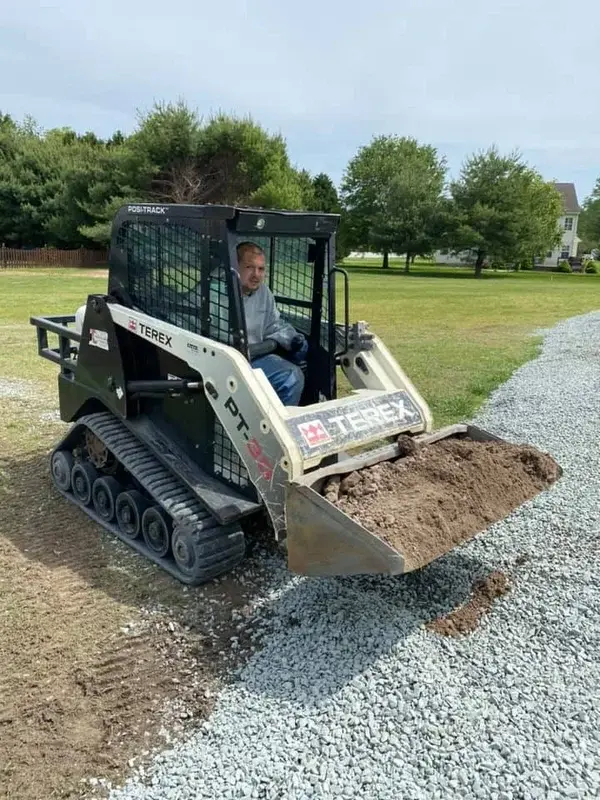 Grading machine leveling soil for site preparation